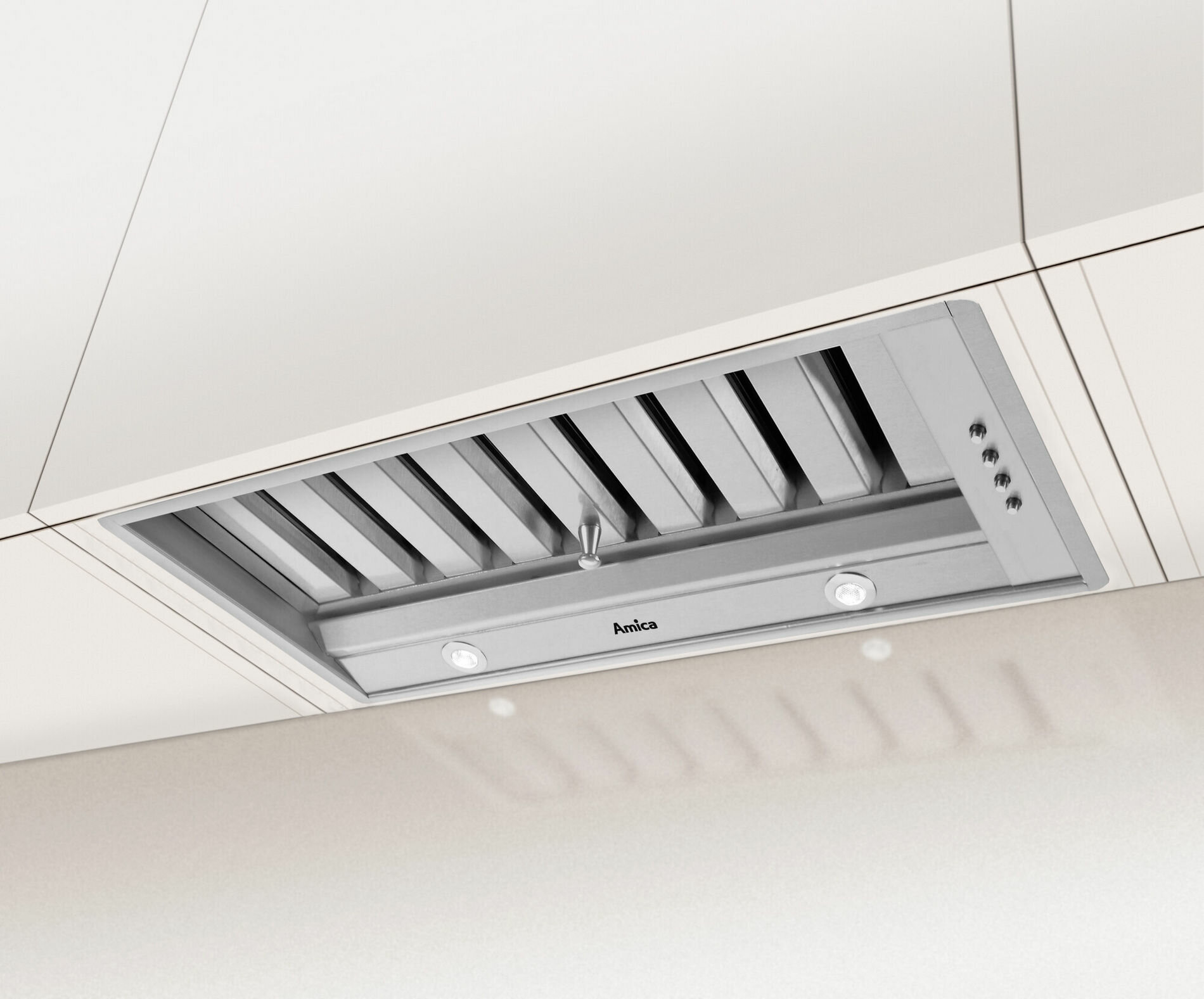 Widok od spodu srebrnego okapu z oświetleniem i filtrami. Zamontowany w białej szafce.