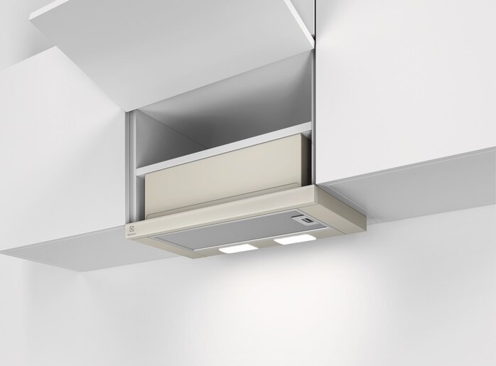 Szafka kuchenna z okapem. Beżowy okap ze światłami i szarym otworem wentylacyjnym.