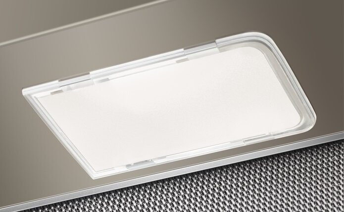 Zbliżenie światła okapu kuchennego, prostokątne białe światło za przezroczystą plastikową osłoną.