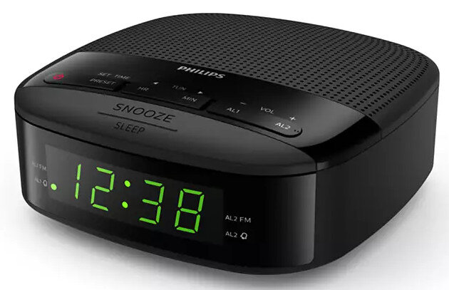 Czarny cyfrowy budzik Philips. Wyświetla godzinę 12:38 zielonymi cyframi, z przyciskami drzemki i snu.