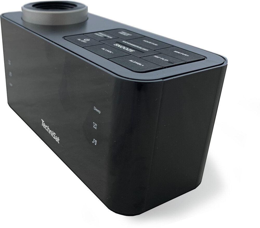 Czarny budzik TechniSat z przyciskami i górnym głośnikiem. Zegar stoi na białej powierzchni.