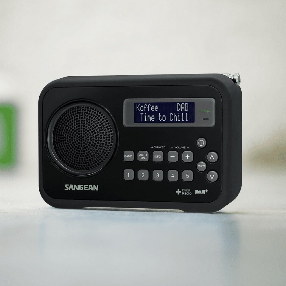 Czarny radio cyfrowe. Wyświetlacz pokazuje informacje o stacji. Przyciski i głośnik są widoczne.