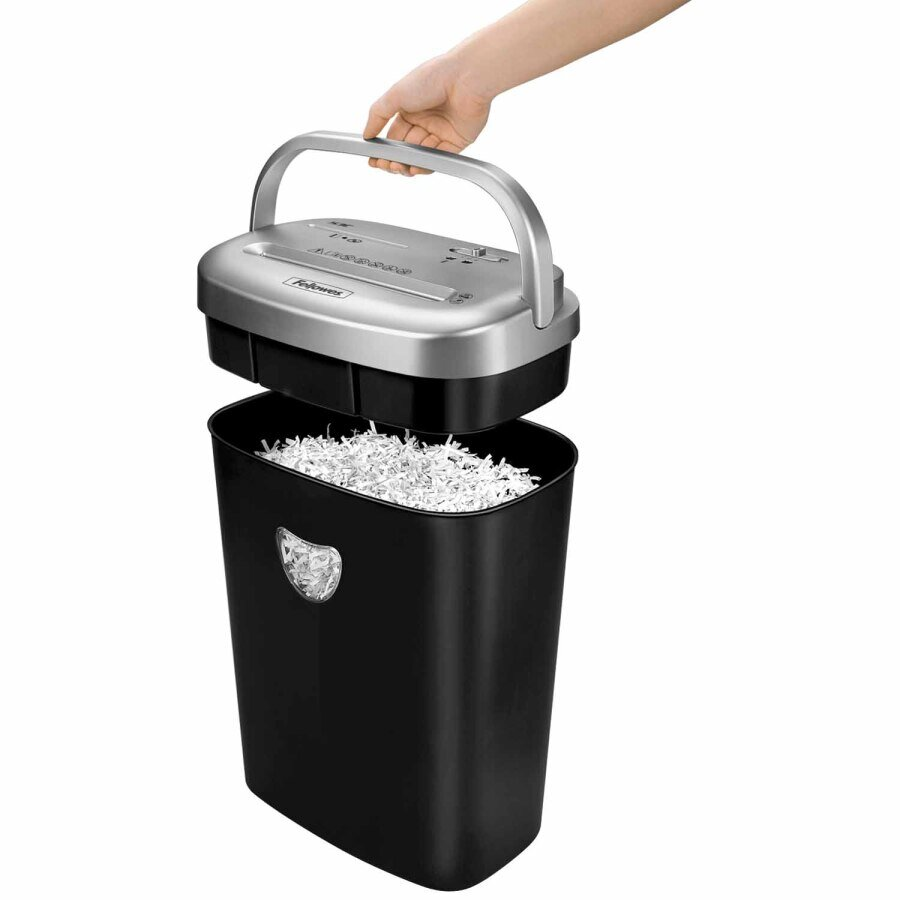 Osoba podnosi górną część niszczarki do papieru. Niszczarka ma kolor czarny i srebrny.