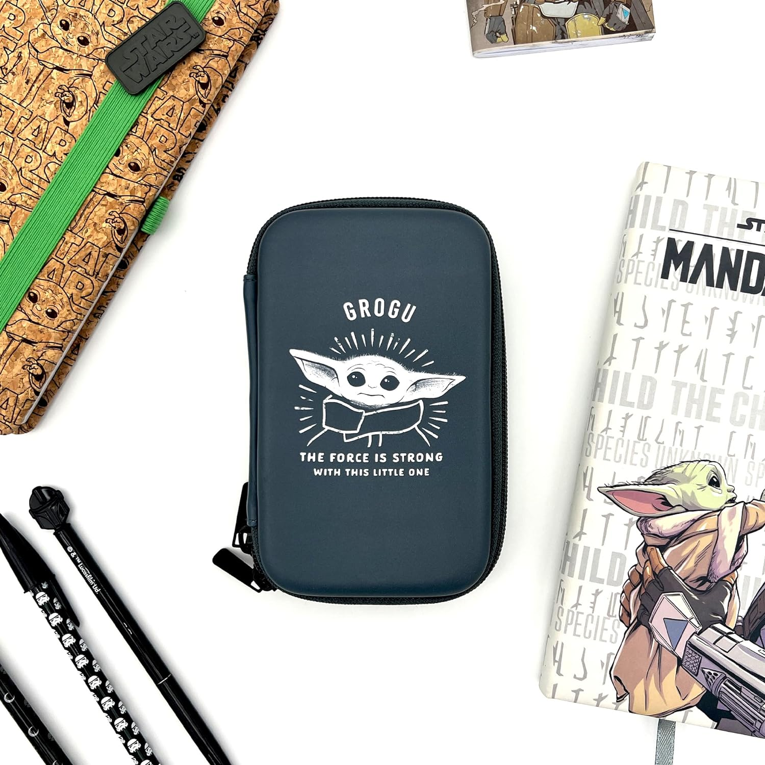 Estuche Grogu con artículos de Star Wars sobre una superficie blanca.