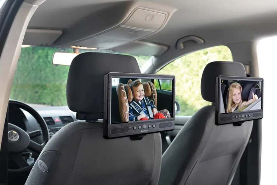 Due schermi poggiatesta auto mostrano bambini che guardano video. Un interno auto è lo sfondo.