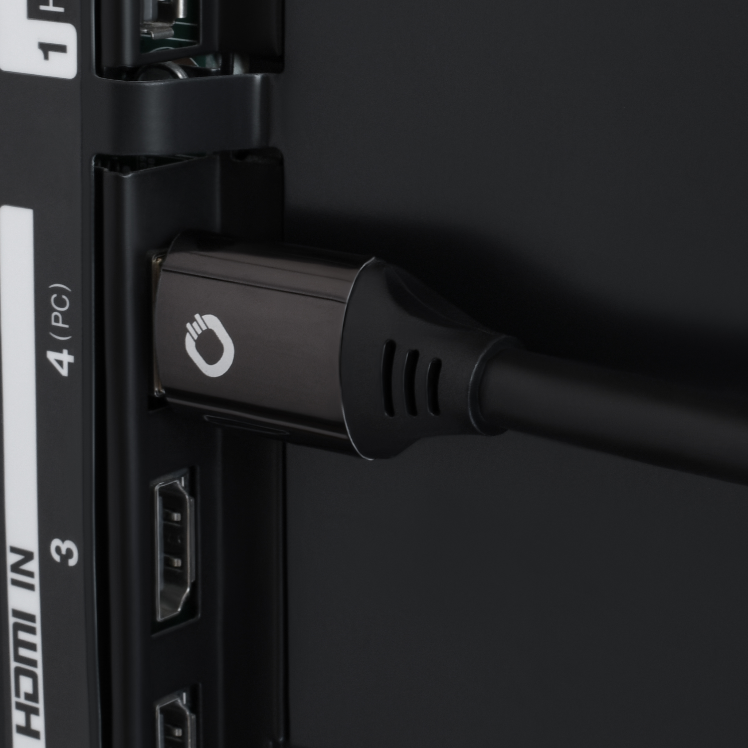 Een zwarte HDMI-kabel aangesloten op de achterkant van een tv. De connector heeft een wit logo.