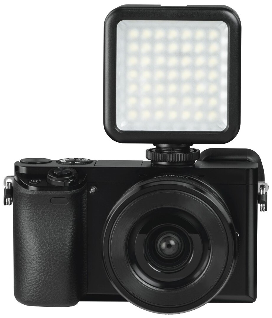 Czarny aparat z dołączonym światłem na górze, na białym tle.