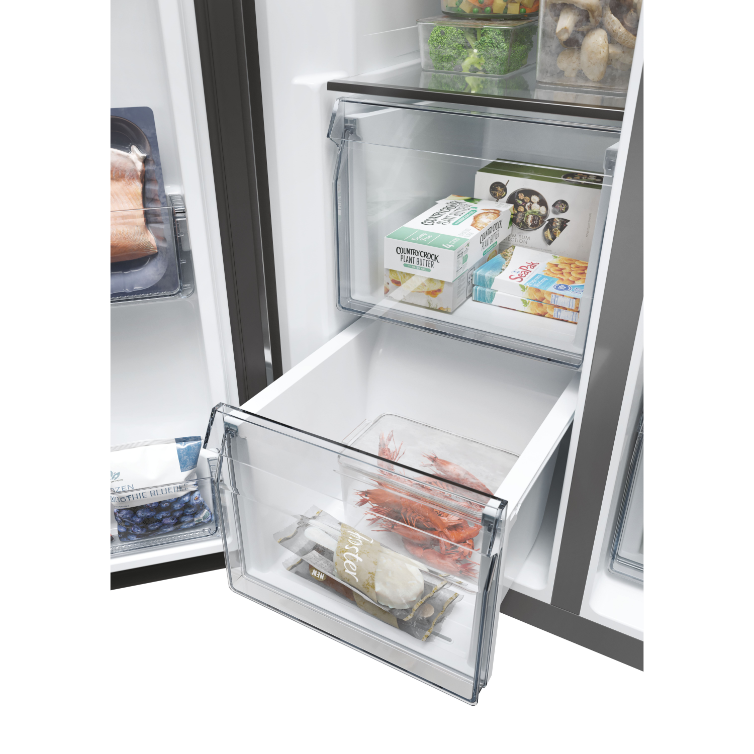 Refrigerator interior with drawers containing food.