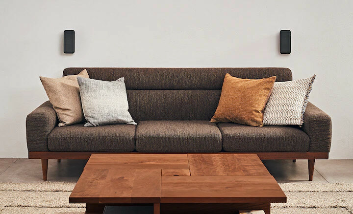 Brązowa kanapa z poduszkami i drewnianym stolikiem kawowym.