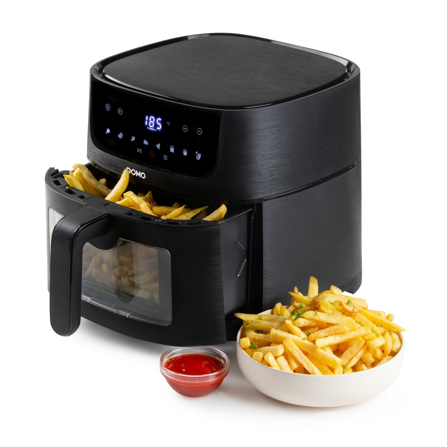 Friteuse à air noire avec frites à l'intérieur, un bol de frites et un bol de ketchup sur fond blanc.