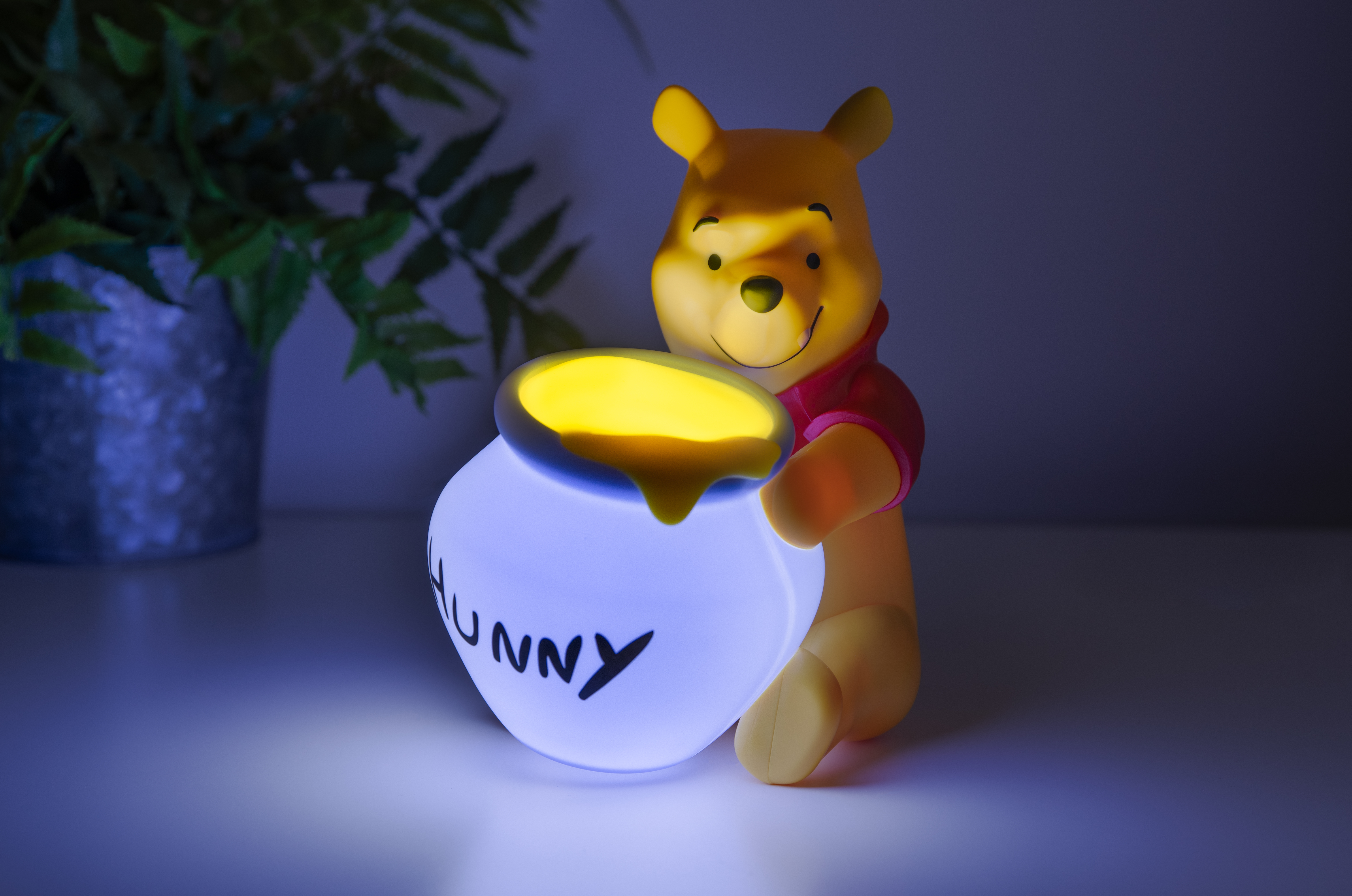 Winnie Puuh Lampe mit Honigtopf, leuchtend im Dunkeln.