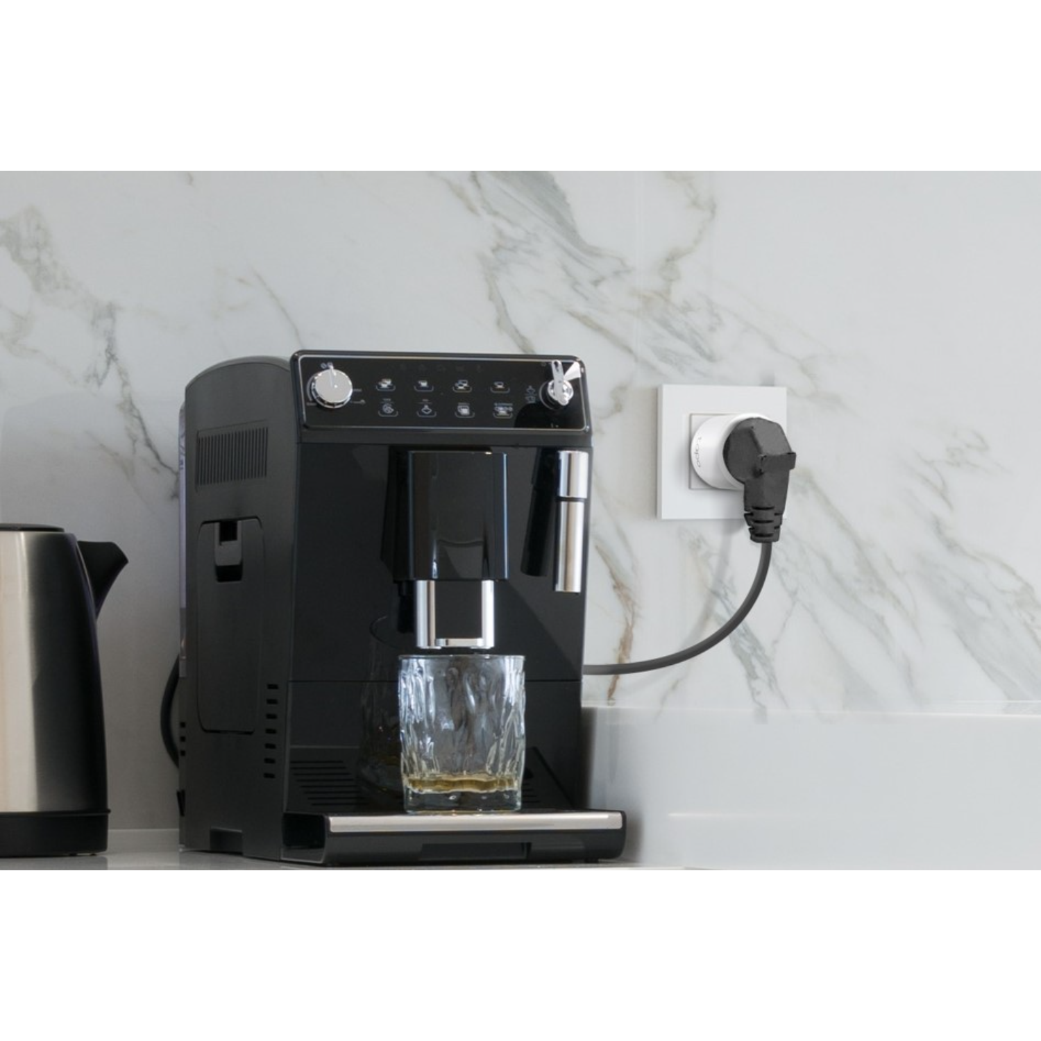 Koffiezetapparaat met een glas koffie dat wordt ingeschonken, naast een waterkoker.