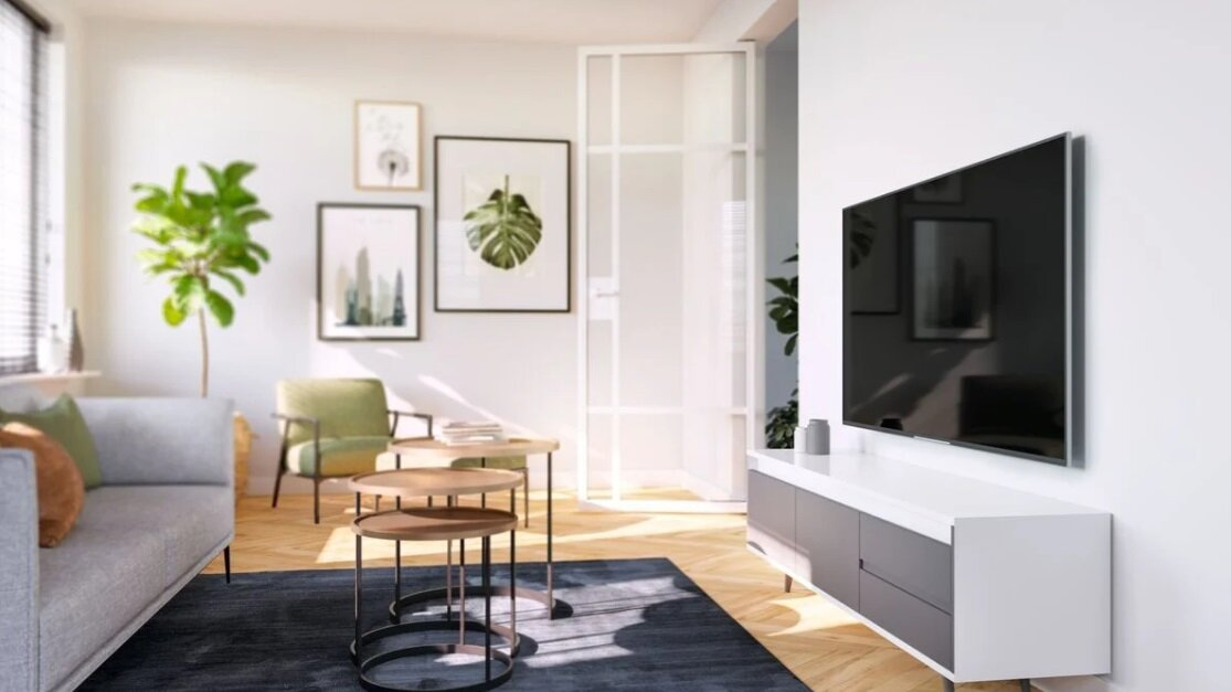 Scena salonu z telewizorem, sofą, dziełami sztuki i drewnianą podłogą.