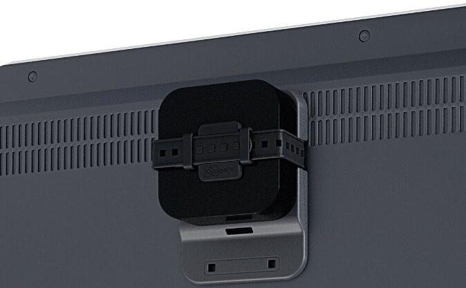 Czarne urządzenie przymocowane do tyłu ciemnego telewizora, zabezpieczone czarnym paskiem.