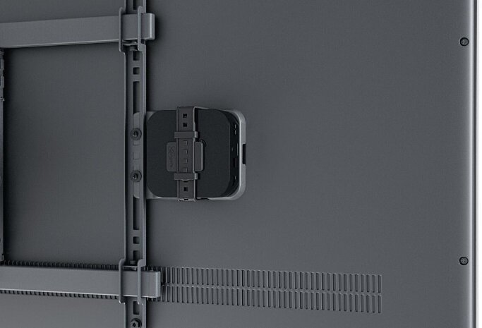 Telewizor z czarnym urządzeniem zamontowanym z tyłu za pomocą wspornika.