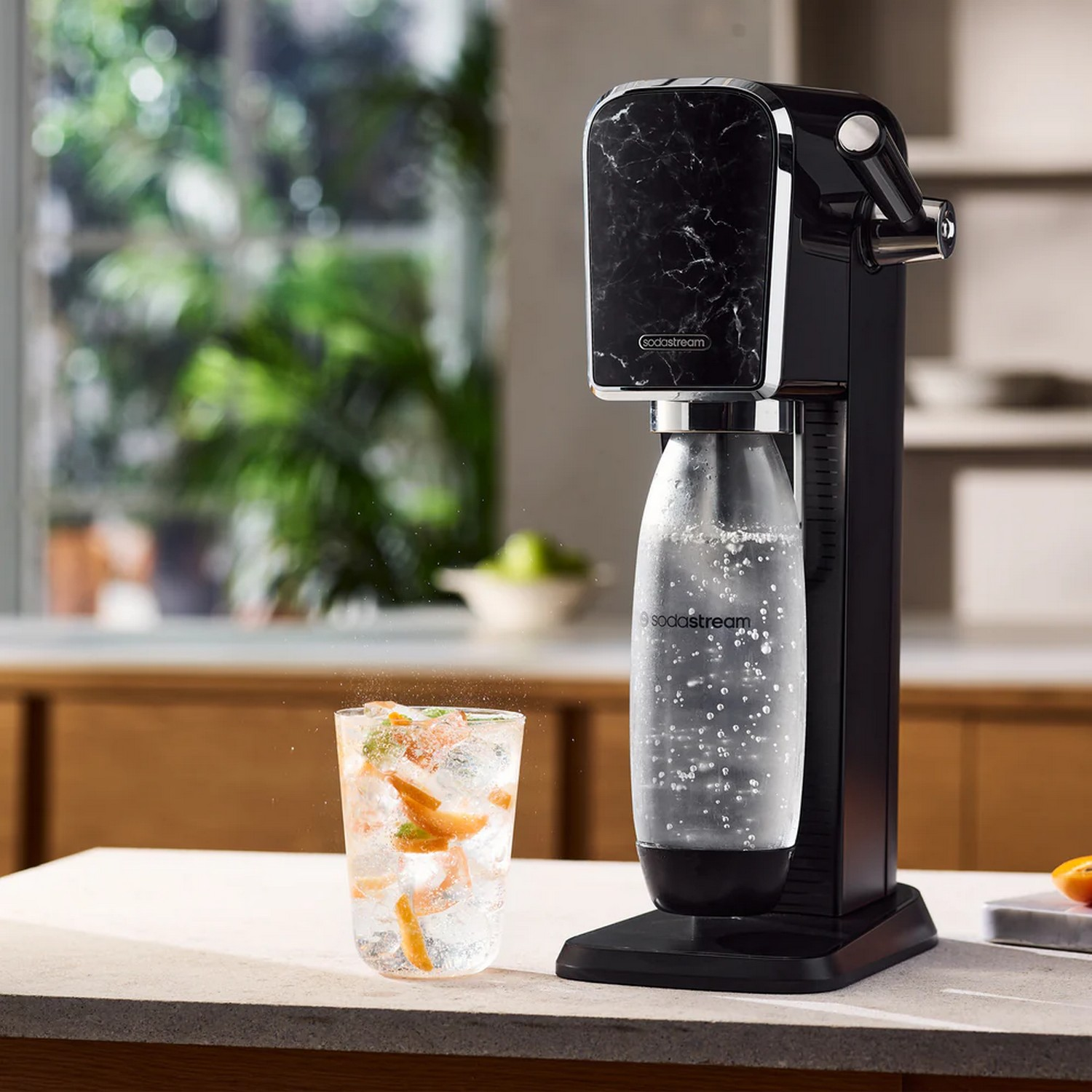 SodaStream machine with a glass of infused water.
