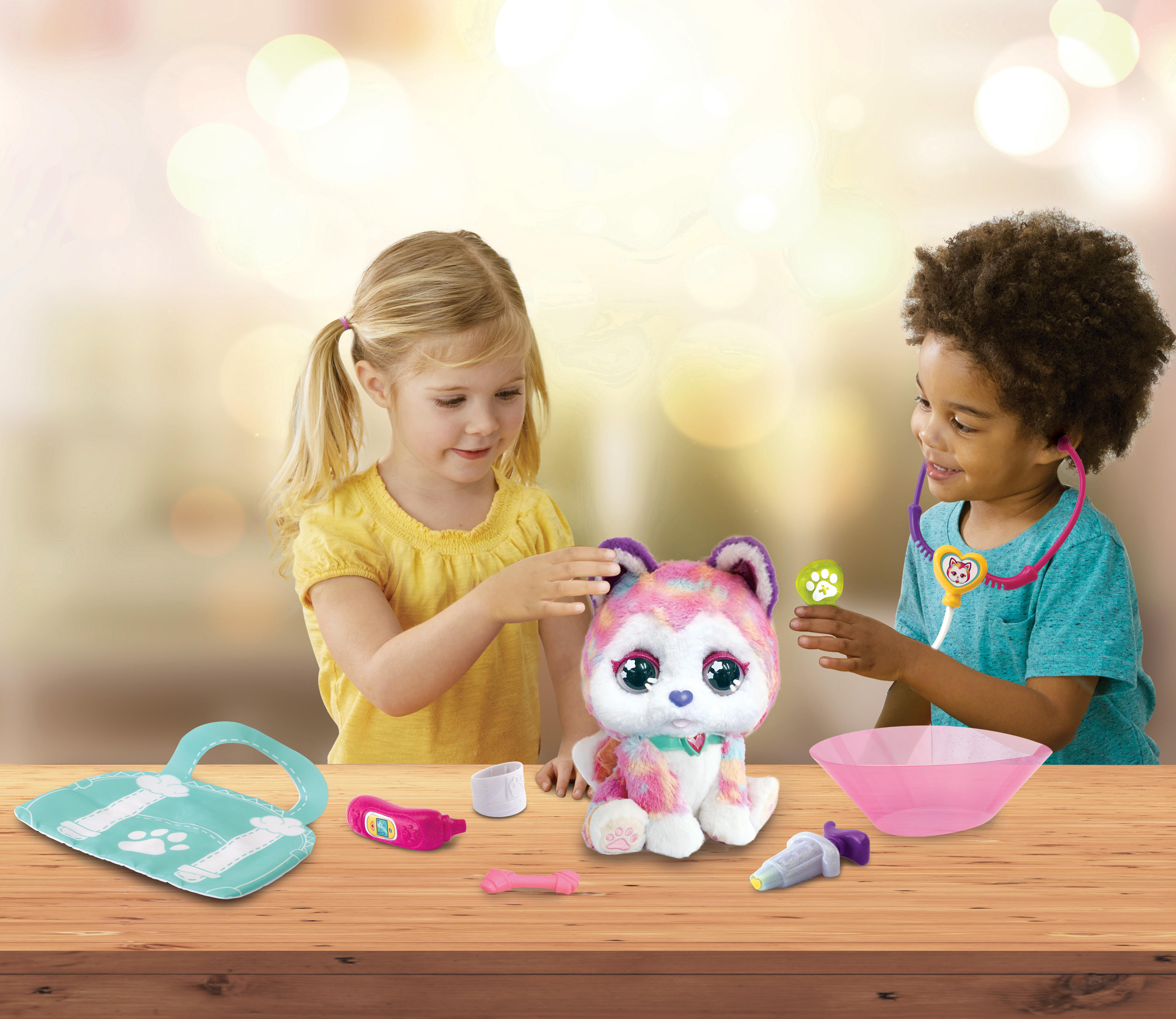 Kinder spielen Tierarzt mit einem Spielzeughund und Spielzeug-Werkzeugen auf einem Tisch.