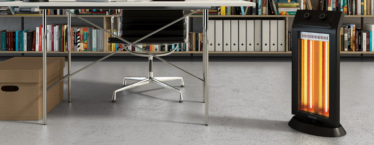 Czarny grzejnik stoi obok biurka z książkami i segregatorami.