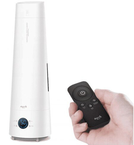 Biały nawilżacz z pilotem trzymany w dłoni. Nawilżacz ma cyfrowy wyświetlacz i cylindryczny kształt.