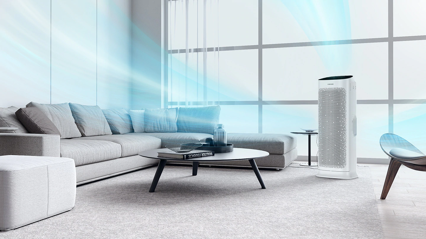 Salon z oczyszczaczem powietrza. Szara sofa, okrągły stół i biały oczyszczacz na dywanie. Niebieski strumień powietrza.