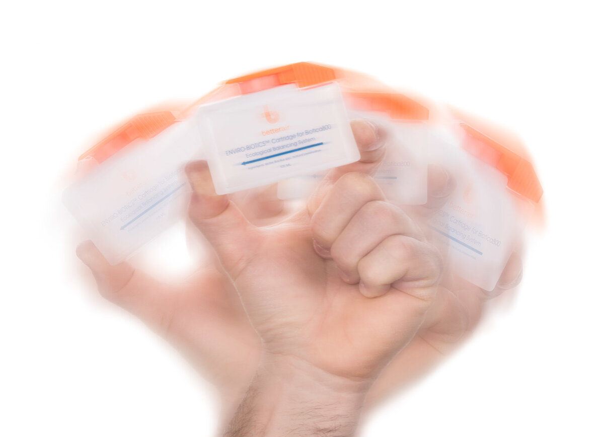 Dłoń potrząsa kilkoma białymi i pomarańczowymi pojemnikami. Tekst rozmazany.