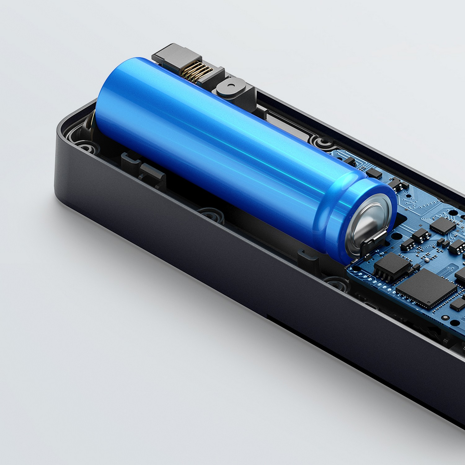 Een blauwe cilindrische batterij in een zwart elektronisch apparaat. Printplaat zichtbaar.