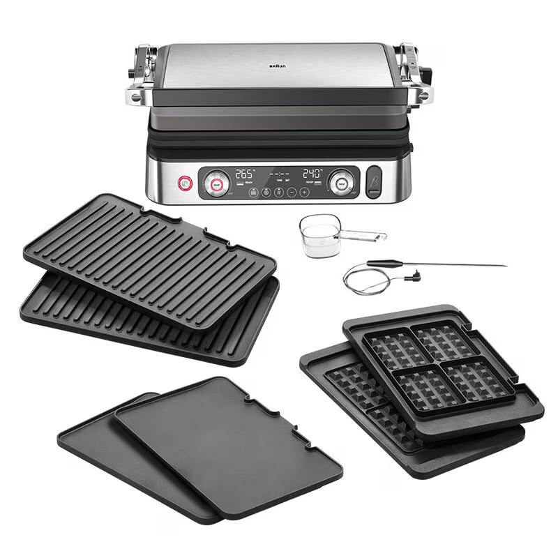 Un multi-grill Braun con accessori: piastre, un misurino e un termometro.