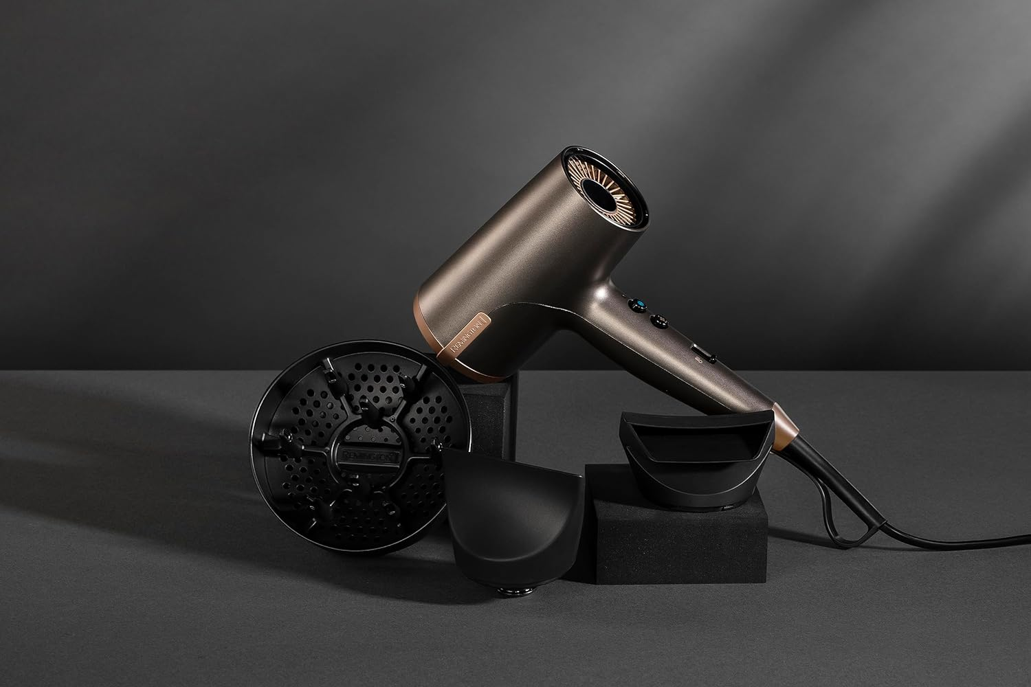 Un secador de pelo con accesorios, sobre un fondo gris oscuro. Varios accesorios incluidos.
