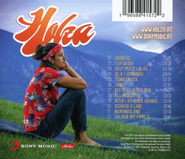 Albumcover mit einem Mann, der auf einer Matte sitzt, mit Text und Titelliste auf der rechten Seite.