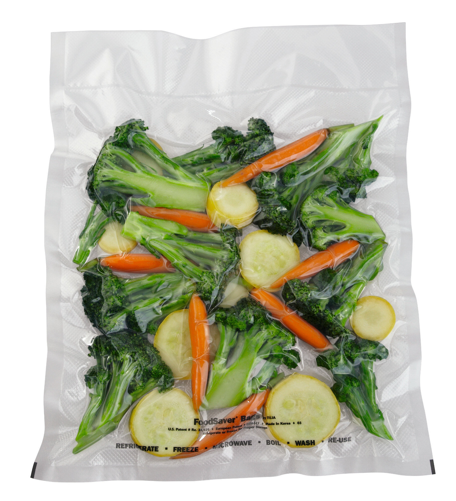 Przezroczysta plastikowa torba zawiera świeże brokuły, marchewki i plastry dyni.