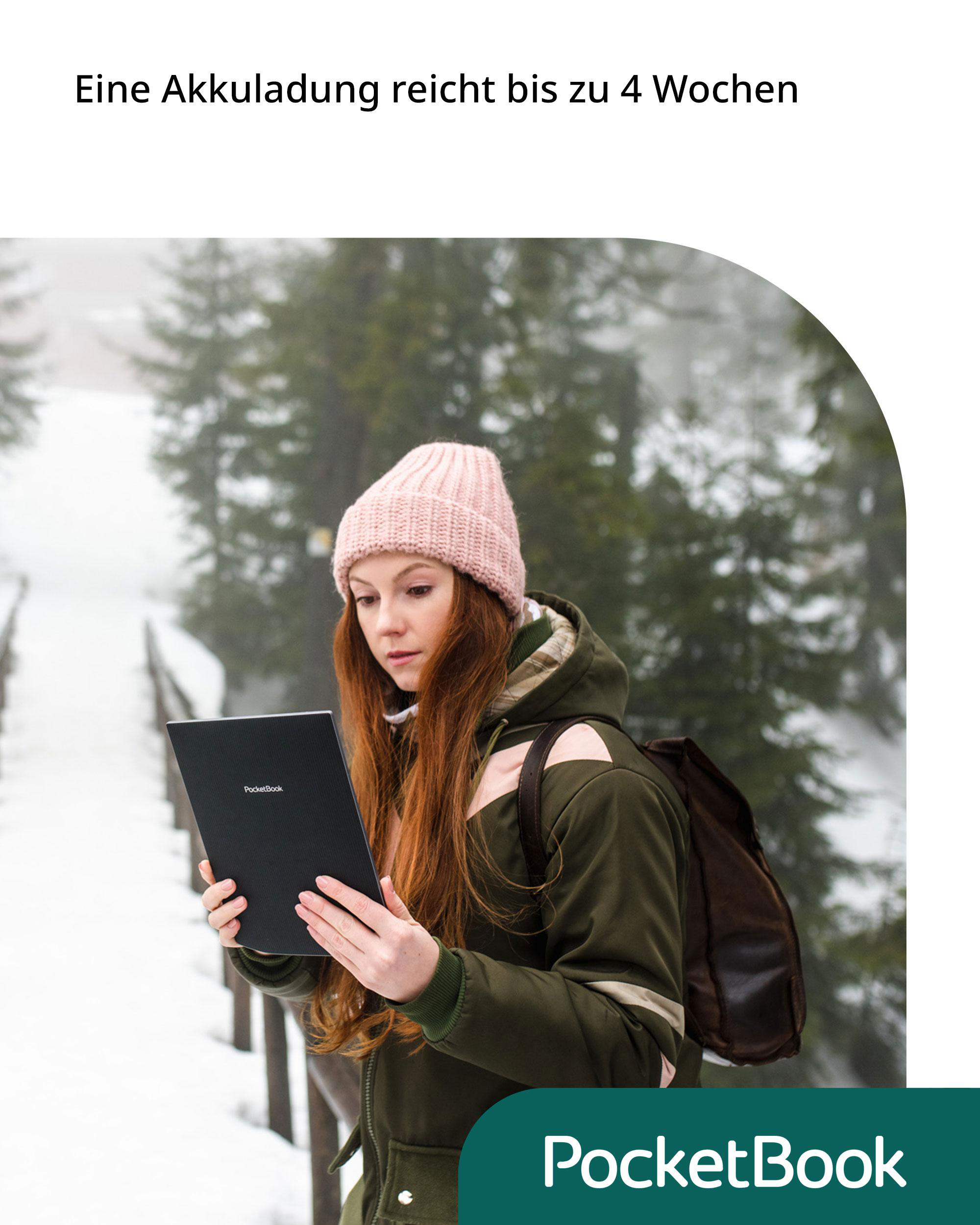 Eine Frau in grüner Jacke und rosa Hut hält einen schwarzen PocketBook-Reader in einer verschneiten Landschaft.