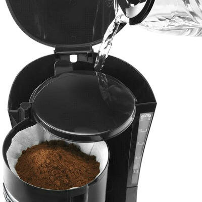 Wlewanie wody do czarnego ekspresu do kawy z fusami w filtrze.