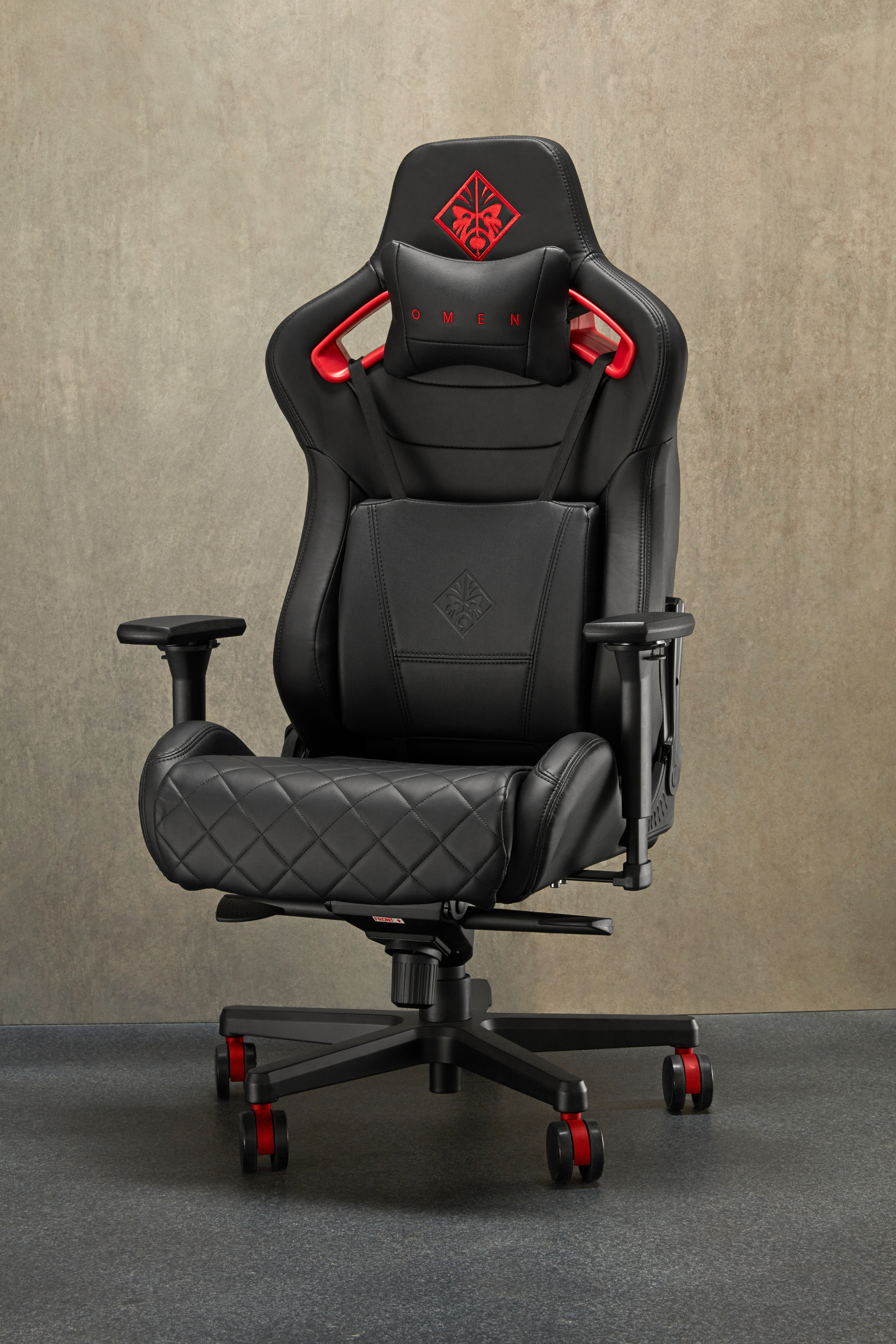 Ein schwarzer und roter Gaming-Stuhl mit dem OMEN-Logo. Er hat Räder, eine Kopfstütze und eine Lendenwirbelstütze.