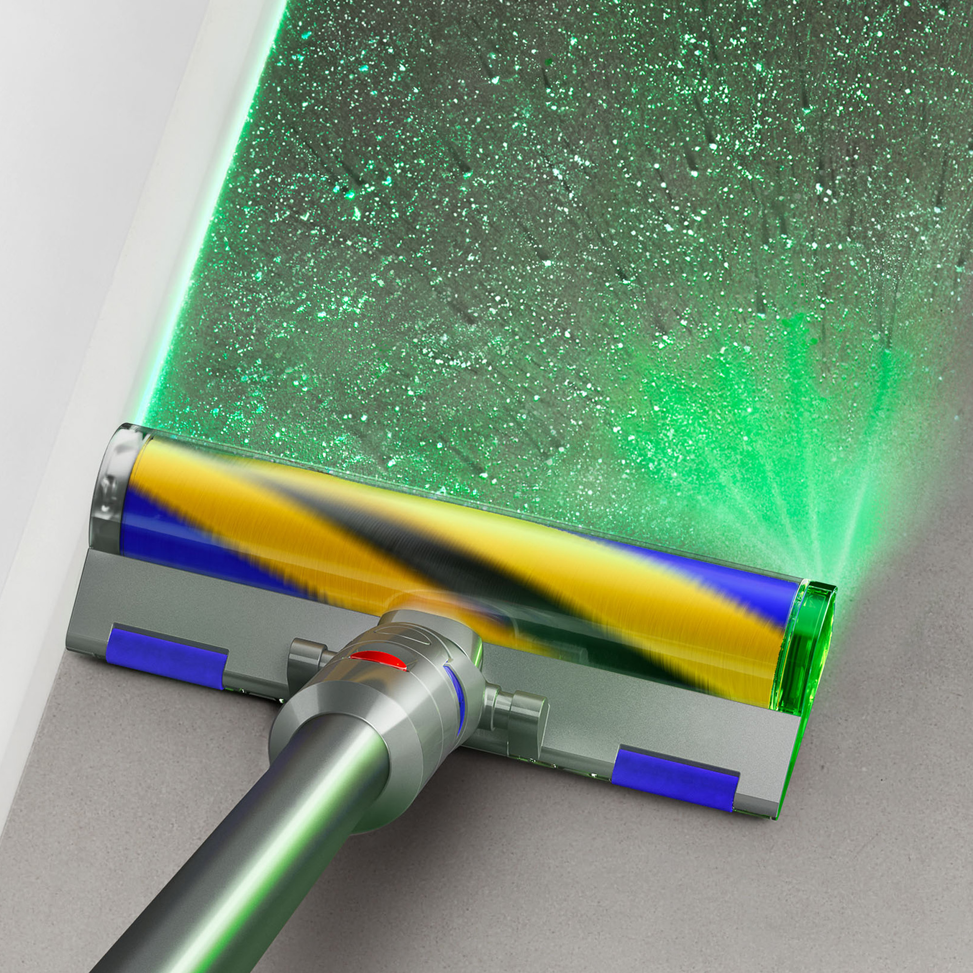 Un primo piano della testina di un aspirapolvere con una luce verde che brilla su una superficie polverosa.