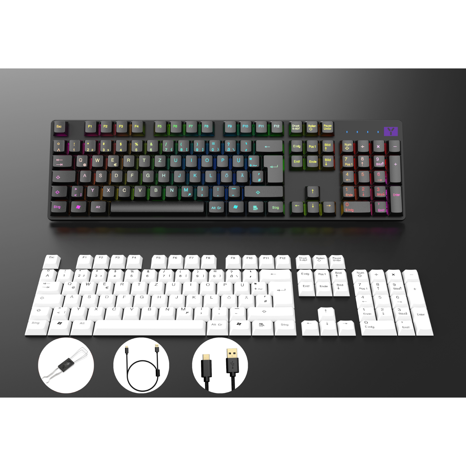Two computer keyboards, one black and one white. Both have keys and cables below.