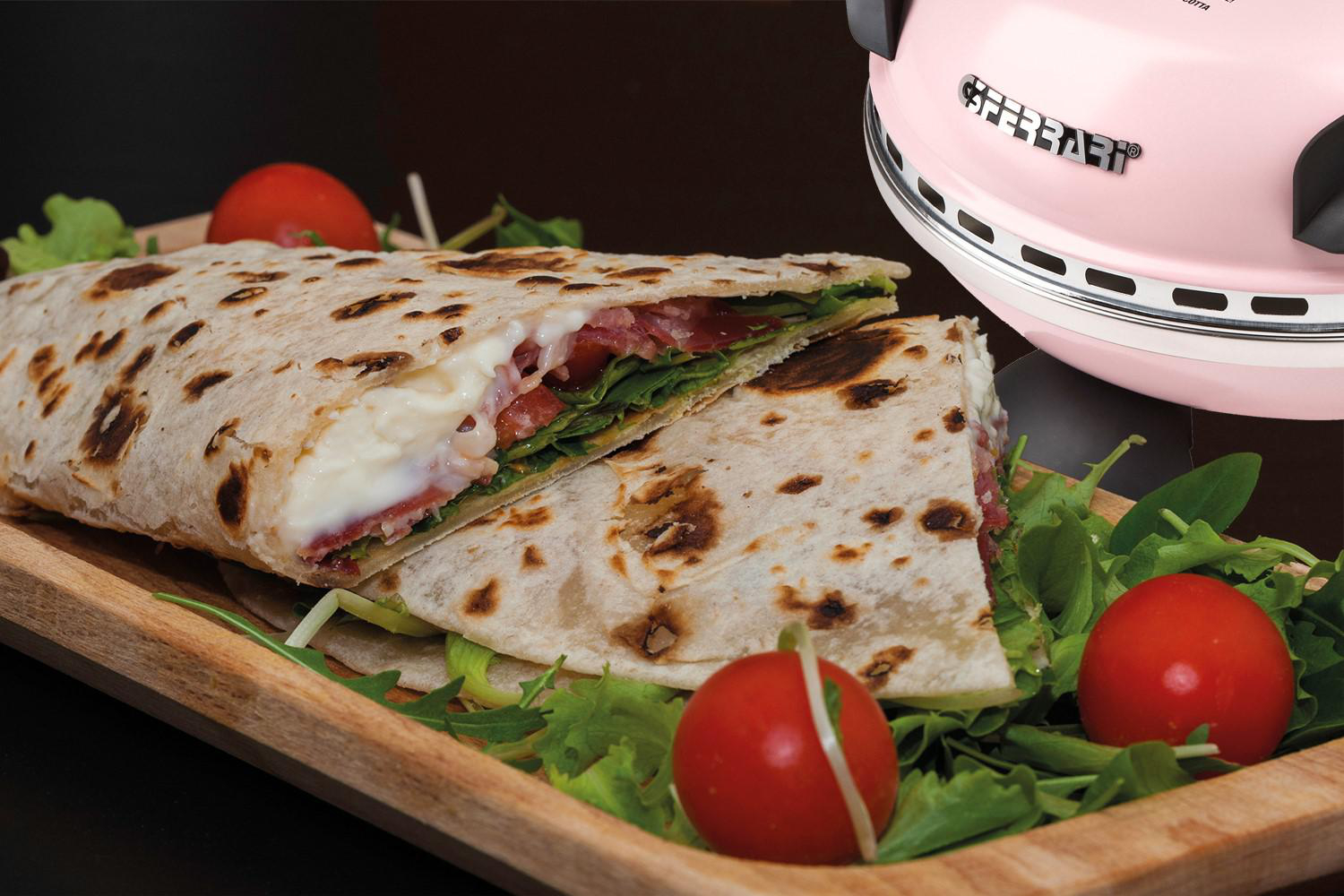 Ein in zwei Hälften geschnittenes Fladenbrot, gefüllt mit Käse, Tomaten und Grünzeug.