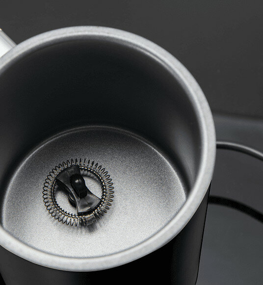 Zbliżenie spieniacza, z metalowym wnętrzem i sprężyną spiralną na dnie.