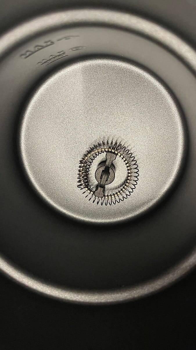 Wnętrze kubka ze stali nierdzewnej z narzędziem przypominającym trzepaczkę pośrodku.