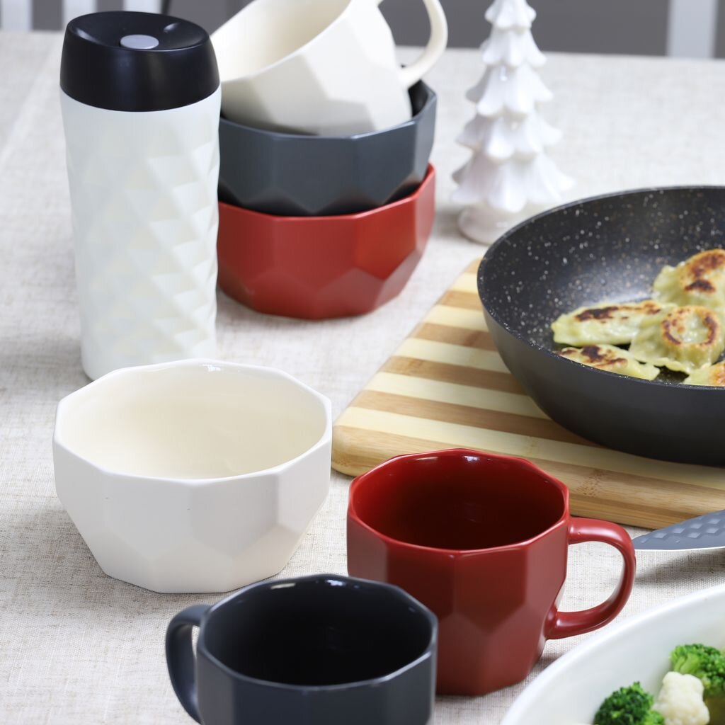 Nakrycie stołu z filiżankami, miseczkami i patelnią. Biały, czarny, szary i czerwony.