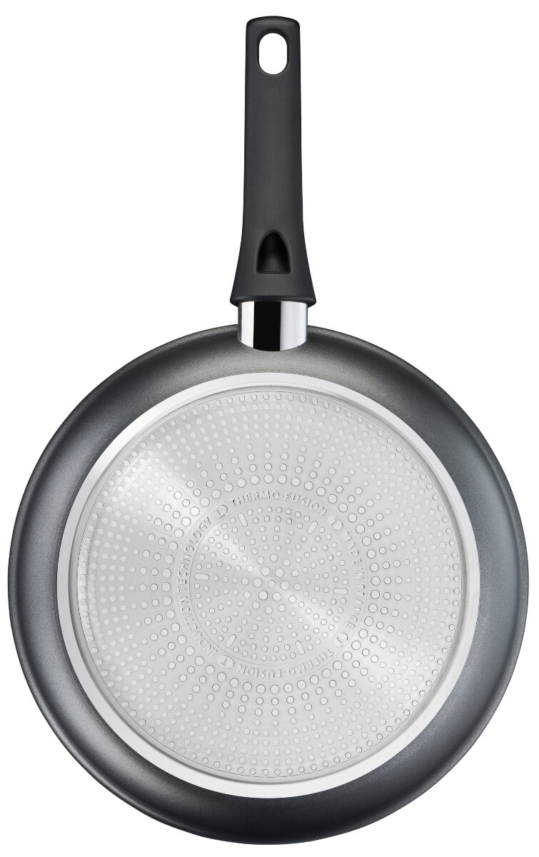 Spód szarej patelni z czarnym uchwytem. Widoczna nazwa marki.