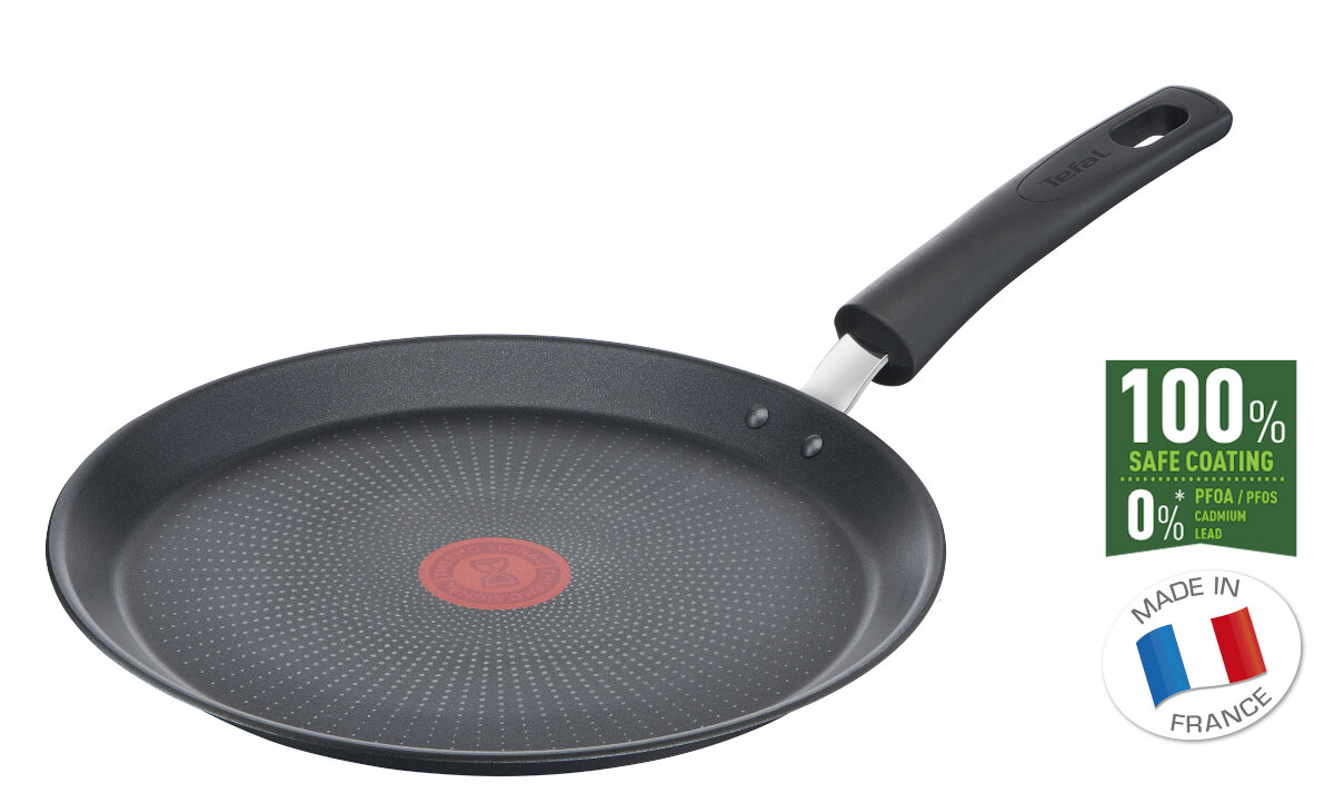 Zbliżenie na spód czarnej patelni ze srebrnym wnętrzem.