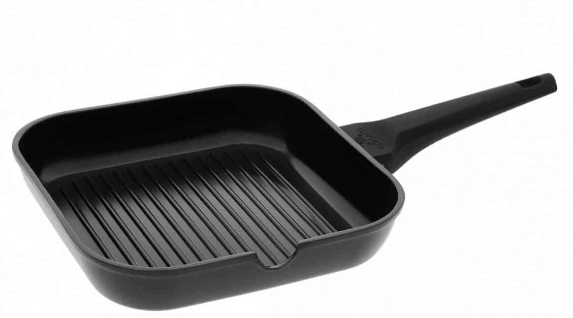 Czarny grill z uchwytem. Patelnia ma żłobienia na powierzchni do gotowania, idealna do grillowania.