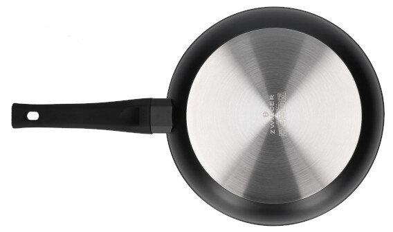 Spód czarnej patelni z uchwytem, pokazujący metalową podstawę.