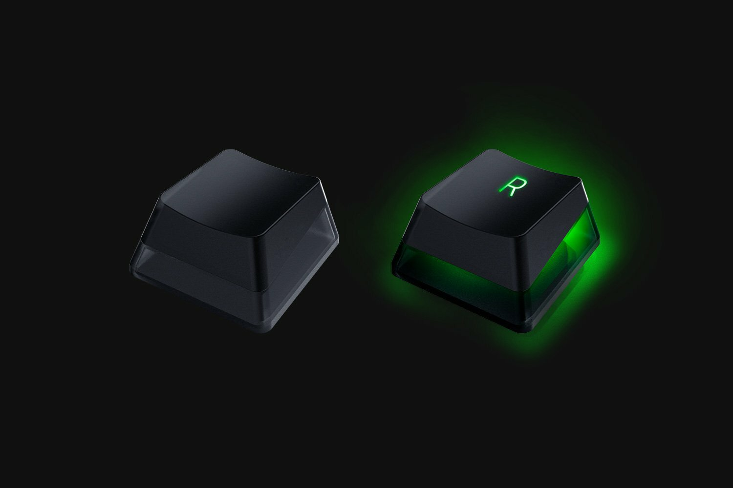 Dwa czarne nakładki na klawisze Razer; jeden gładki, drugi podświetlony na zielono, pokazujący literę 'R'.