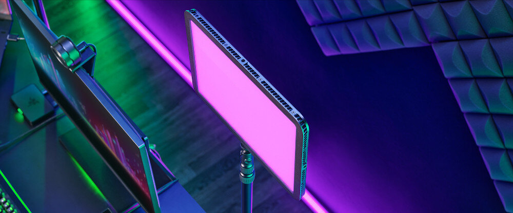 Konfiguracja streamingu z dwoma monitorami i różowym światłem LED. Scena jest ciemna z neonowym oświetleniem.