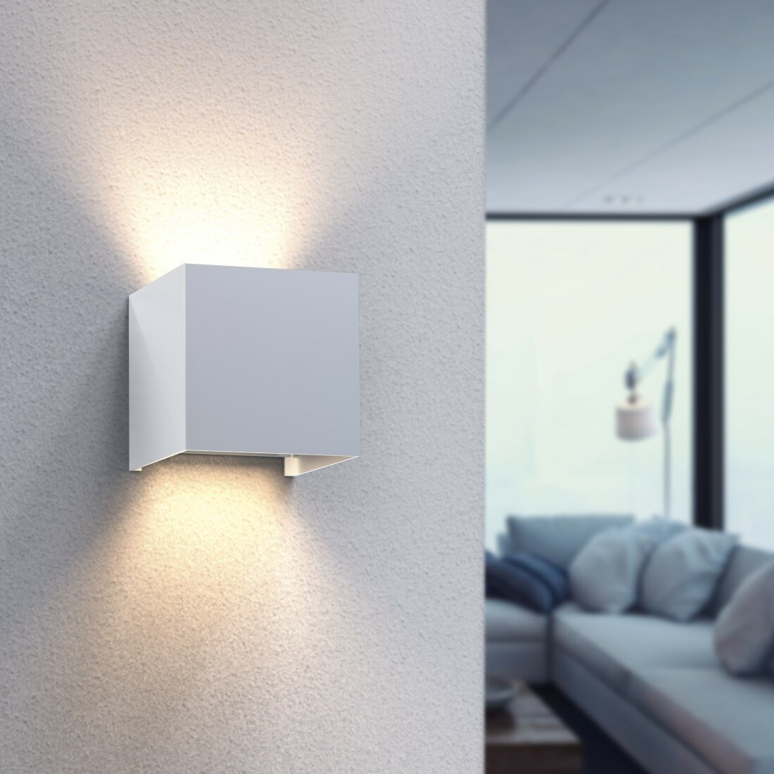 Biała kwadratowa lampa ścienna. Ma dwa światła skierowane w górę i w dół.