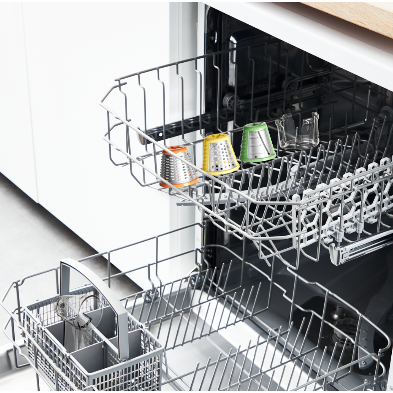 Dishwasher interior with colorful grater attachments in racks.