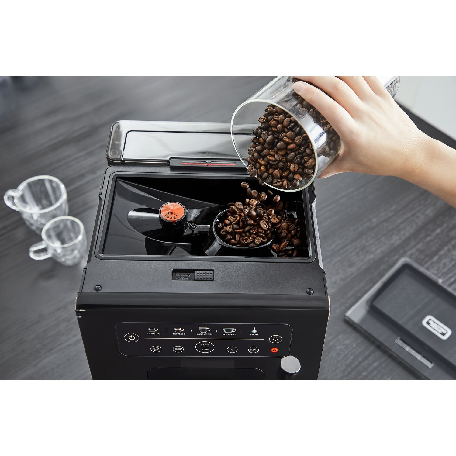 Een persoon die koffiebonen in een koffiemachine giet.