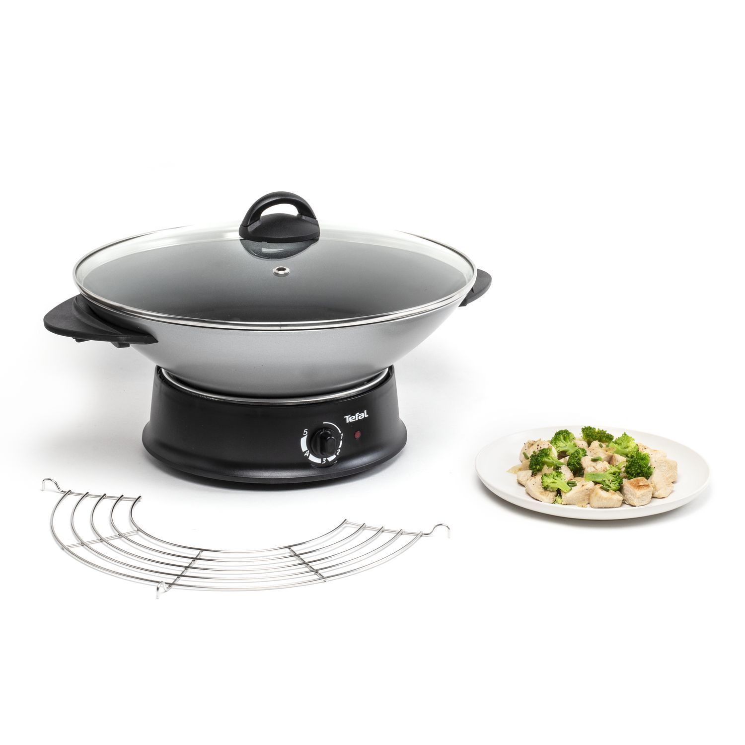 A Tefal wok with a lid, a rack, and food on plate.