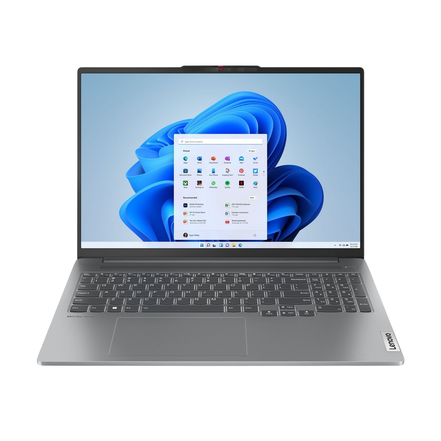 Zilveren laptop open op een tafel, met Windows 11 bureaublad met app-pictogrammen. Lenovo logo zichtbaar. Zwarte rand.